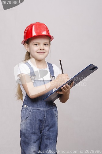 Image of child five years worth helmet and writes in folder