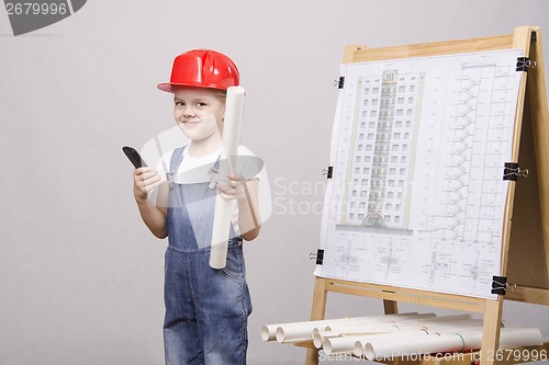 Image of Child stands a phone at blackboard with drawing