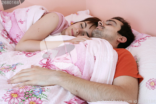 Image of Young couple sleeping together.