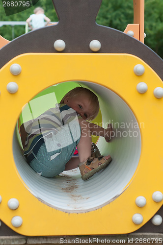 Image of Young boy sitting in crawl tube