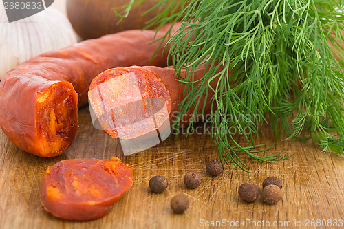 Image of Chorizo sausage sliced on wood chopping board