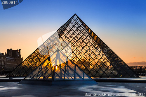 Image of Sunset shines through the glass pyramid of the Louvre museum