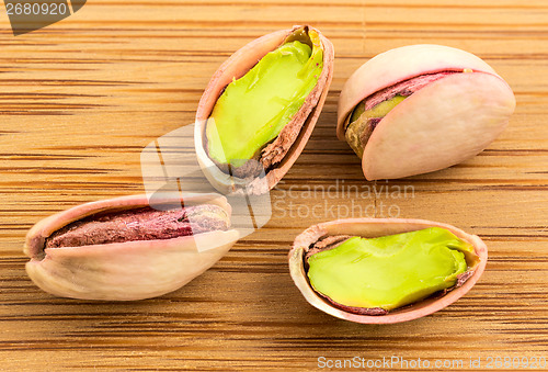 Image of A stack of roasted pistachios on wood