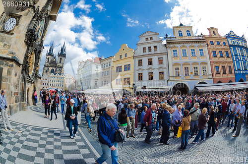 Image of Tourists walk around the Old Town Square in Prague waiting for s