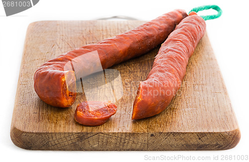 Image of Chorizo sausage sliced on wood chopping board