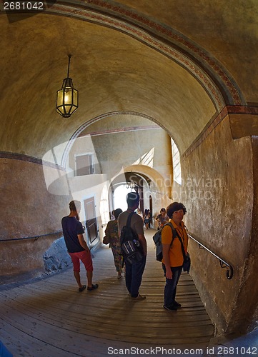 Image of Tourists walk along the corridors of a medieval castle