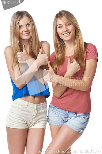 Image of Happy two girl friends gesturing thumbs up