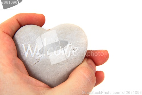 Image of heart with word welcome ni human hands