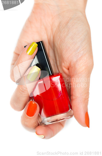 Image of A bottle of red nail polish in a female hand