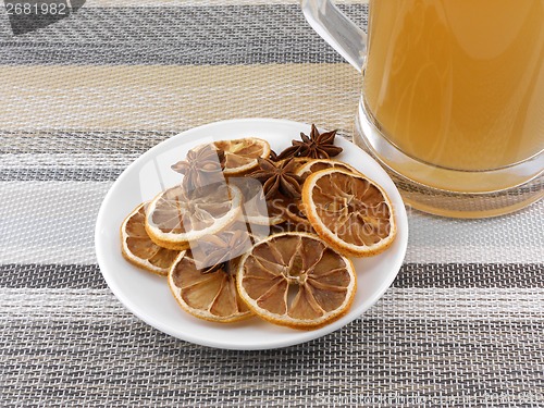 Image of beer mug with cinnamon and lemon on white plate