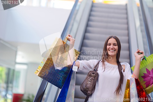 Image of Happy young woman in a shopping mall