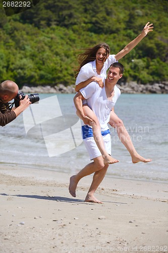Image of happy couple have fun on the beach
