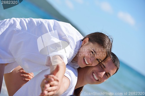 Image of happy couple have fun on the beach