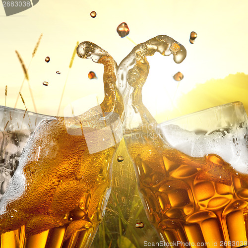 Image of Splash of beer against wheat field and sunset