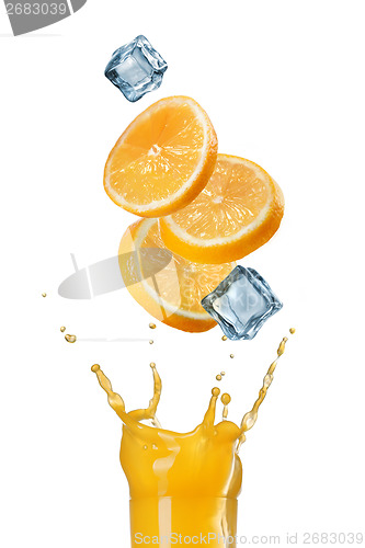 Image of slices of orange falling into juice splash in glass isolated on 