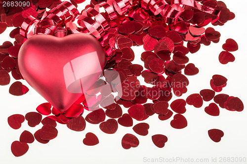 Image of small red confetti and big hearts on white background