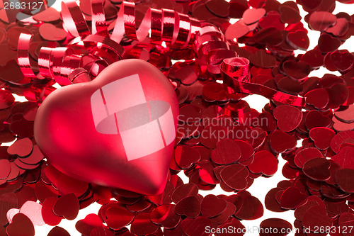 Image of small red confetti and big hearts on white background