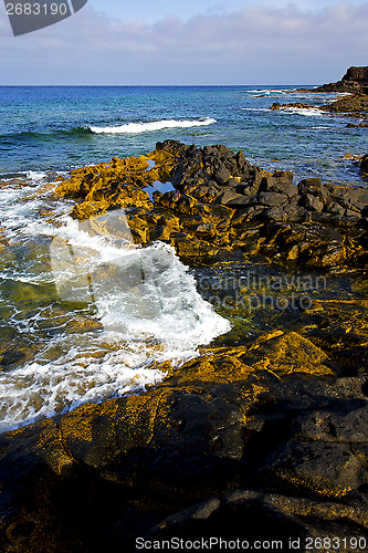 Image of beach  light   foam rock spain  stone sky cloud   