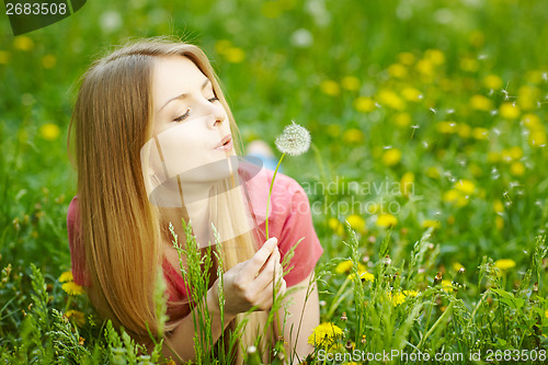 Image of Girl blowing on a dandelion