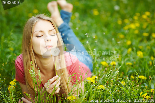 Image of Girl blowing on a dandelion