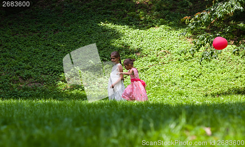 Image of Two little girls walking in park