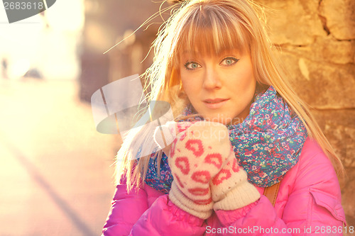 Image of Woman warming her hands in mittens