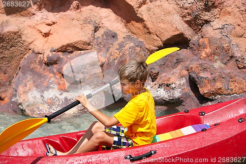 Image of Happy boy paddling kayak on the river and enjoying a lovely summ