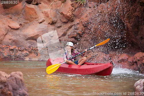 Image of Happy little girl on a kayak on a river at summer 