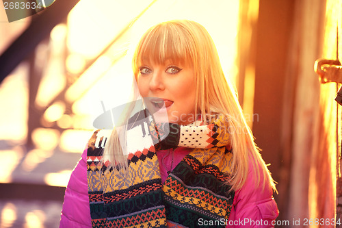 Image of Happy woman sticking out tongue in the sun