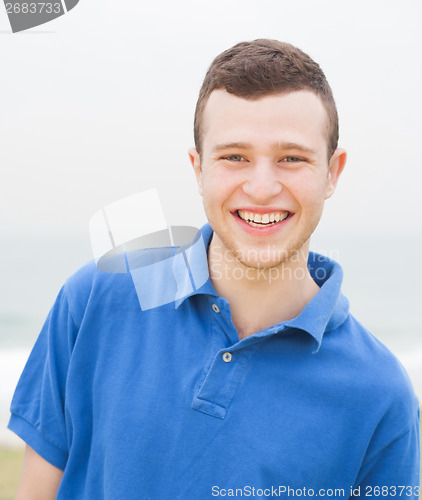 Image of Smart young man smiling at the beach