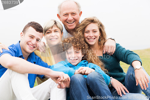 Image of Portrait of family sitting on beach lawn