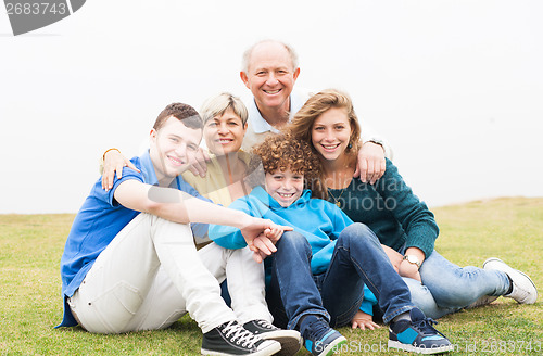 Image of Happy family sitting in the lawn