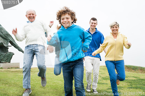 Image of Happy family running at the lawn