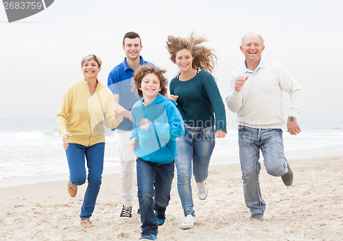 Image of Happy family jogging atthe beach