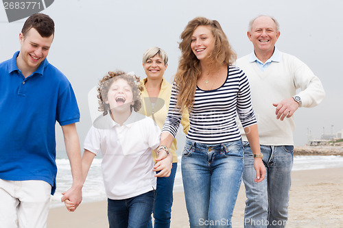 Image of Happy family walking on the beach