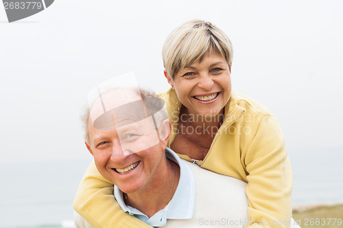 Image of Mature man giving woman piggyback