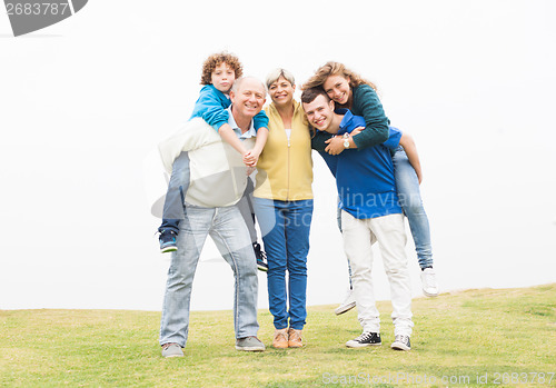 Image of Happy family standing together in lawn