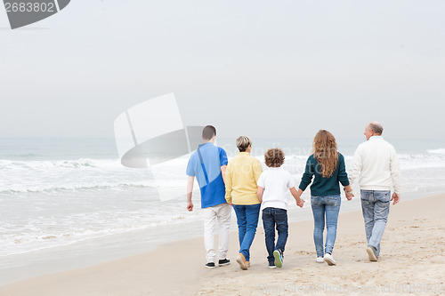 Image of Happy family walking on beach