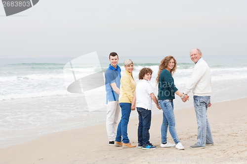 Image of Happy family walking on beach