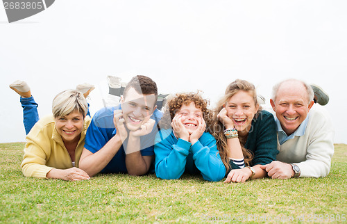 Image of Happy family lying on green lawn