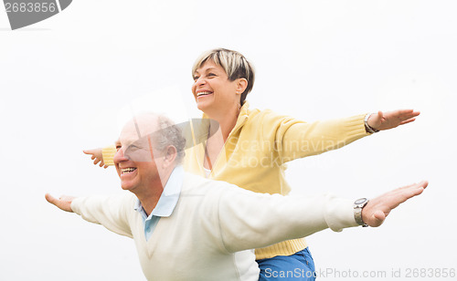 Image of Happy man giving piggyback to woman