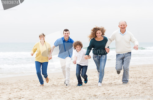 Image of Happy family jugging at the beach