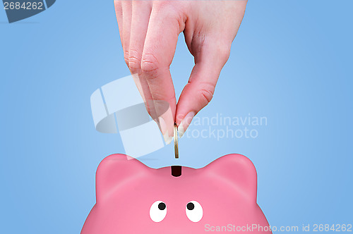 Image of Hand and piggy bank