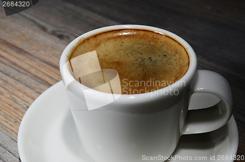 Image of cup of espresso coffee on wooden board