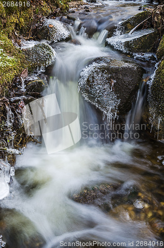 Image of Small waterfall with icicles and ice close up, spring.