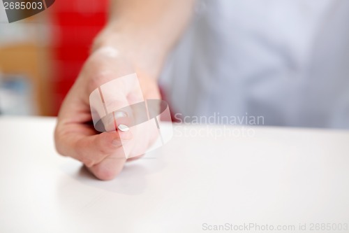 Image of Hand Of Pharmacist Holding Medicine Pill