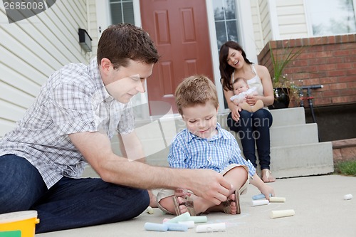 Image of Father And Son Drawing With Chalk on Sidwalk