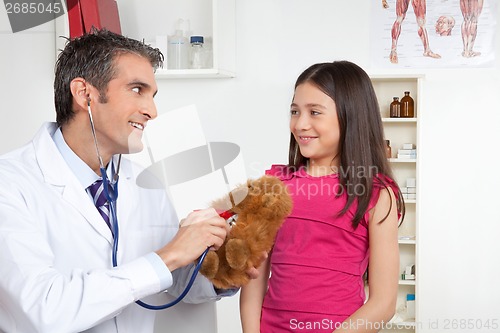 Image of Male Doctor Examining Child's Toy