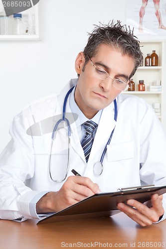 Image of Male Doctor Writing on Clipboard
