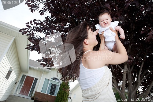 Image of Mother Lifting Daughter Up And Smiling